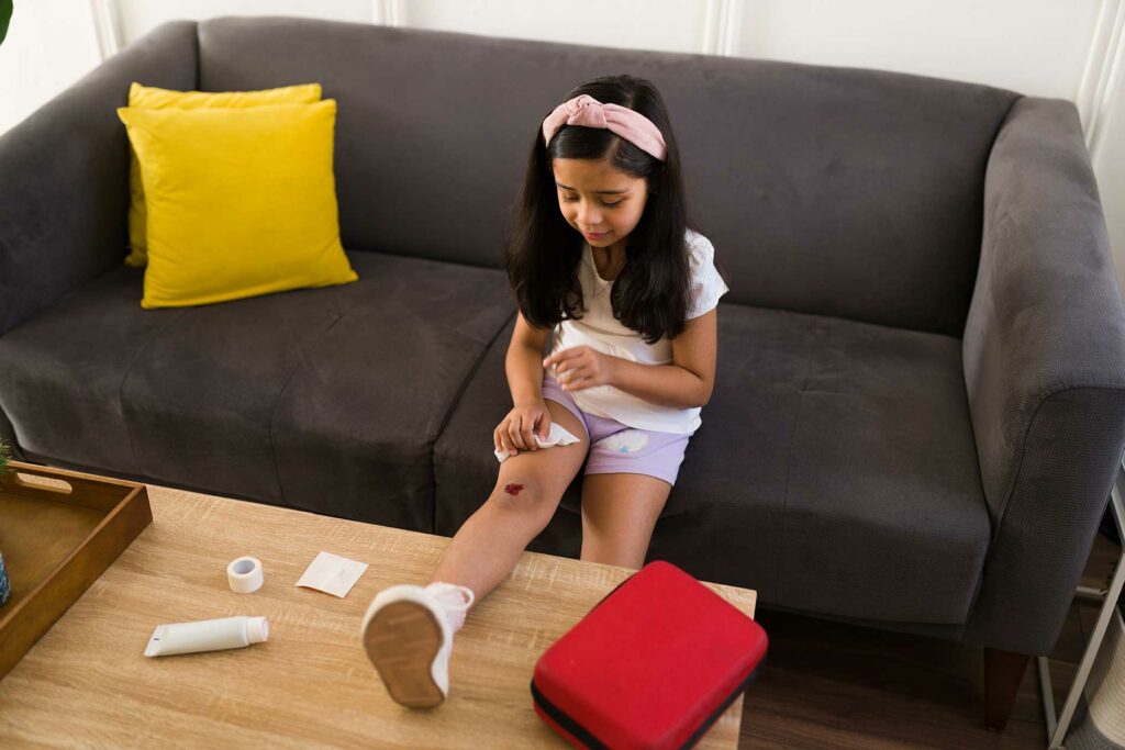 little girl taking care of a wound on her leg