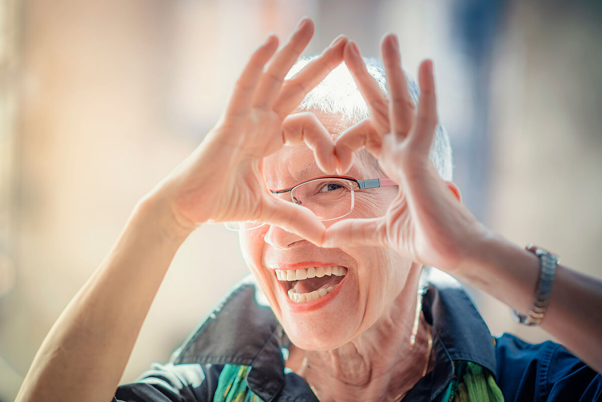 old woman making a heart shape